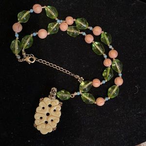 Hand knotted necklace with ivory looking ornament and glass and wooden beads.